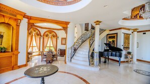 A grand foyer with a piano, a staircase, and a dining area. - Lux Scottsdale/ Carefree family retreat golf pool (Carefree)