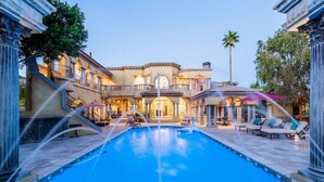 A large swimming pool with a fountain, surrounded by a multi-story building with balconies and outdoor seating. - Lux Scottsdale/ Carefree family retreat golf pool (Carefree)