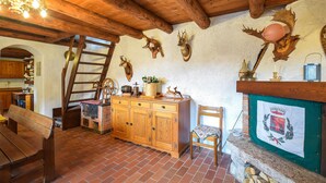 A rustic kitchen with wooden cabinets, a brick floor, and a chandelier. - 2 bedroom nice home in Sovramonte (Sovramonte)
