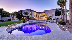 Un'ampia casa con piscina, fontana e un giardino curato.