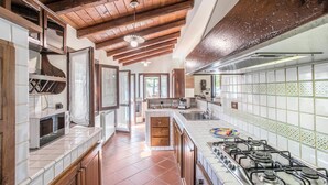 A kitchen with wooden beams, a gas stove, and a tiled backsplash. - 1 bedroom lovely home in Siracusa (Siracusa)