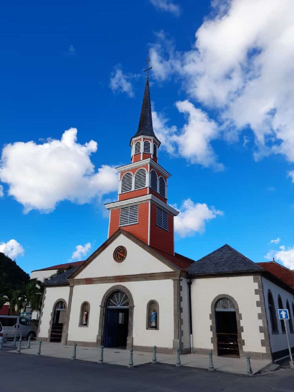 A church with a tall steeple and a clock on the front.