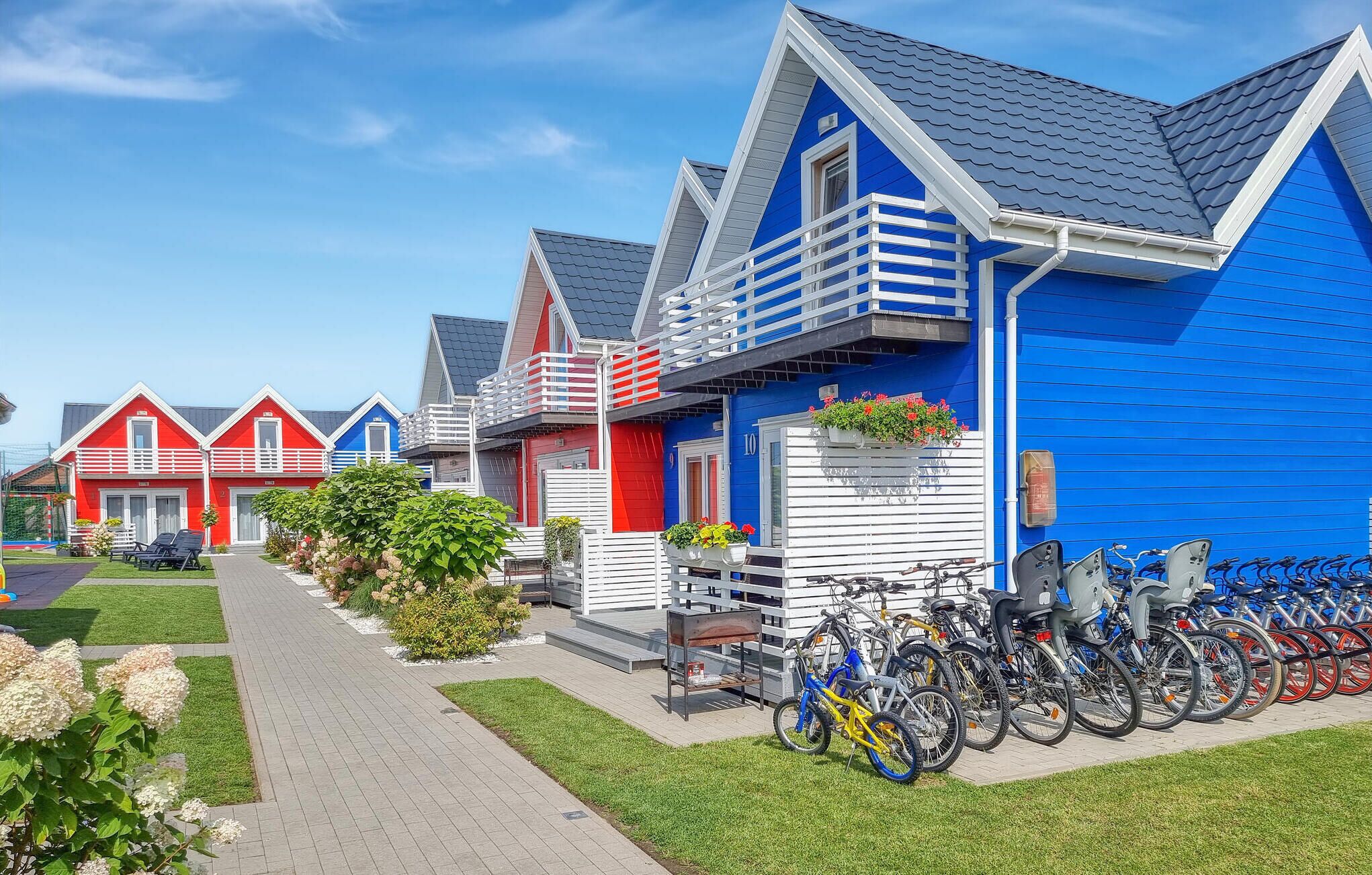 Una hilera de casas coloridas con un aparcamiento para bicicletas al frente.