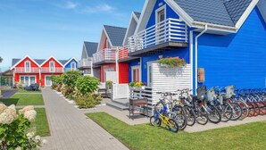Une rangée de maisons aux couleurs vives, avec un espace de stationnement pour vélos devant.