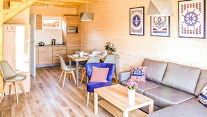 Un intérieur de chalet chaleureux et accueillant, comprenant un coin repas, un canapé et une cuisine.