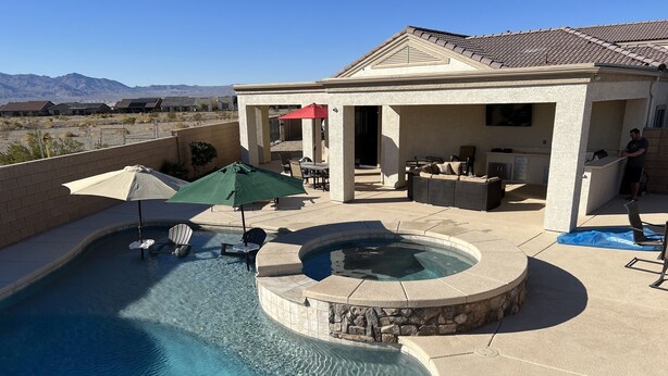 A swimming pool with a hot tub, outdoor furniture, and a covered patio area. - Colorado River Getaway, Resort Pool, Waterslide & Mountain Views (Fort Mohave)