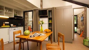 Una cocina compacta con una mesa de madera, sillas y un refrigerador.