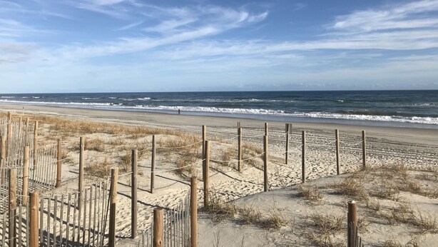 A beach with a wooden fence and sand dunes. - Almost oceanfront Pebble Beach condo, indoor & outdoor pools, 3min to the beach! (Emerald Isle)