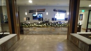 Un vestíbulo de hotel con suelo de baldosas, bancos y un cartel que da la bienvenida a los huéspedes en Grand Colorado, en Peak Eight.