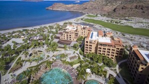 Un complexe hôtelier comprenant plusieurs bâtiments, une grande piscine et un espace de plage.