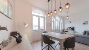 Un salon moderne avec un coin repas, de grandes fenêtres et une vue sur la ville.