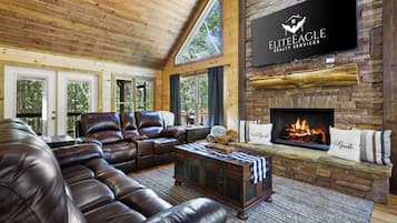 Una sala de estar acogedora con sofás de cuero, una chimenea y un cartel de Elite Eagle Realty Services.