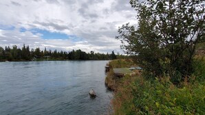 Une rivière avec un quai en bois et un petit bâtiment sur la rive droite.