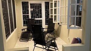 A room with a tiled floor, a table with chairs, barred windows, and a door. - Spacious Property with awesome scenic views-10 minutes from Ocho (Tower Isle)