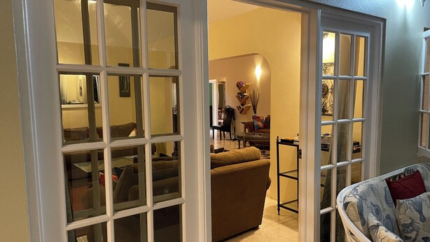 An open door leading to a living room with a sofa, a dining table, and a chair. - Spacious Property with awesome scenic views-10 minutes from Ocho (Tower Isle)