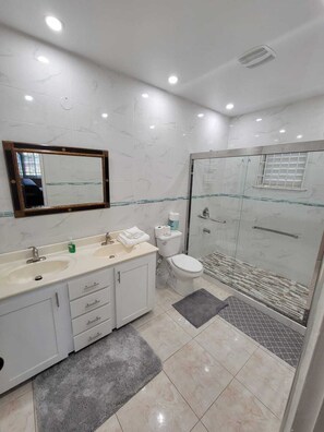 Bathtub, hair dryer, towels, toilet paper