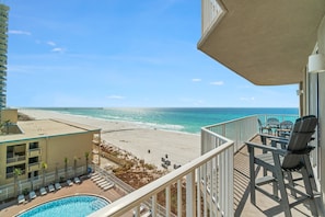 A balcony with a view of the beach and ocean.