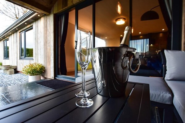 Une table avec un seau à champagne et des verres, un canapé et une vue sur l’extérieur.