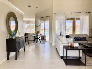 Relax in this stylish living area with a round mirror, dining table, and comfortable seating area.