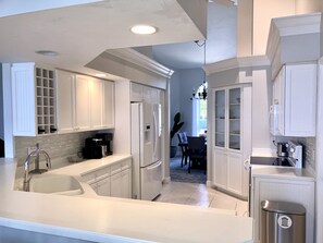 Enjoy cooking in this well-equipped kitchen with a large island, oven, and stainless steel sink.