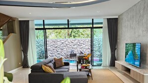 Una sala moderna con sofá, mesa de comedor y televisor.