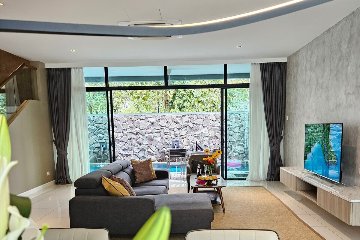 A modern living room with a sofa, dining table, and TV.