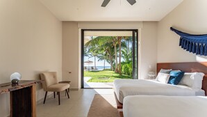 A hotel room with a bed, a desk, a chair, and a view of the ocean. - Medusa🌴 Elegant 1BDR Apartment by the Sea | Luxury & Relaxation in Tulum (TULUM)