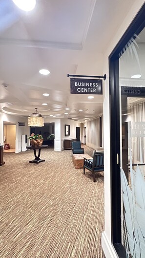 A spacious lobby with a 'BUSINESS CENTER' sign, a chandelier, and seating areas. - Kauai Beach Resort, Top Floor, Pool View (Kauai)