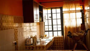 A kitchen with a window, a sink, and cabinets. - Fountain Apartments (Naivasha)