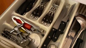 A kitchen drawer with utensils and tools.