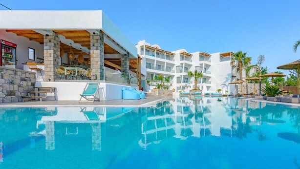 A resort with a swimming pool, outdoor seating, and multiple balconies. - Kouros Home and Suites (Rhodes)