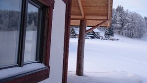 A wooden building with a covered porch and a window.