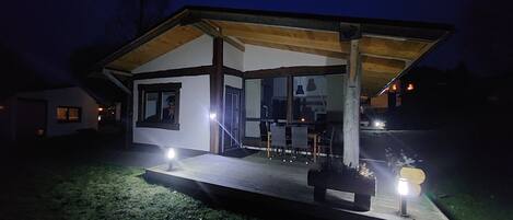 A modern house with a covered patio, a dining area, and a visible kitchen.