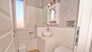 Un baño con bañera, lavabo e inodoro.