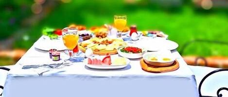 Una mesa al aire libre con varios platos y bebidas.