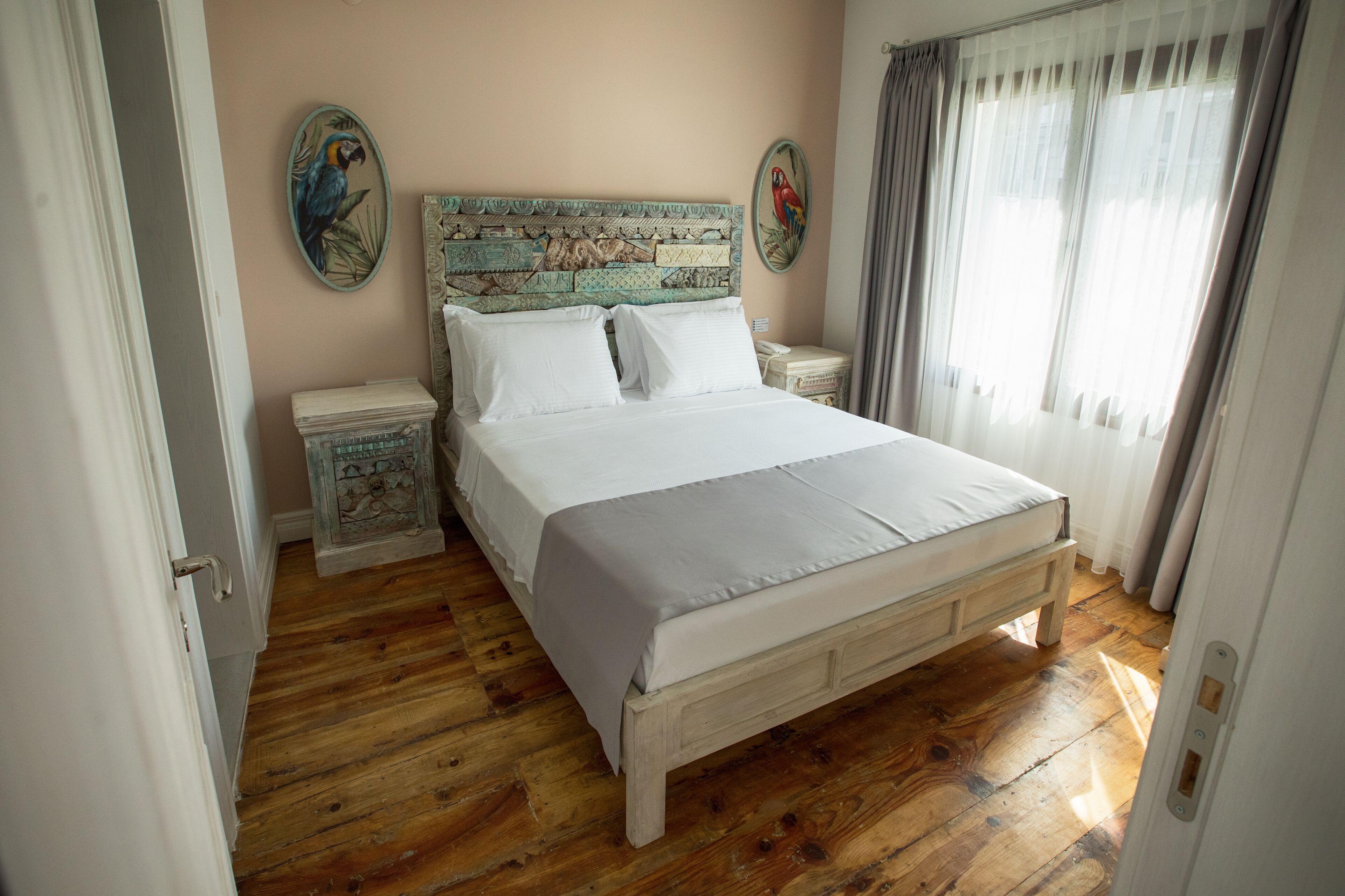 A bedroom with a wooden bed, white bedding, and two nightstands.