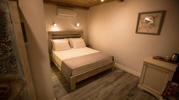 Una camera da letto con un letto di legno, un comodino e un'opera d'arte incorniciata al muro.