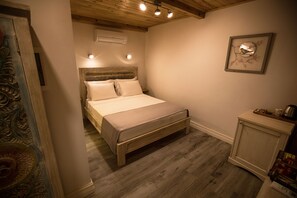 A bedroom with a wooden bed, a nightstand, and a framed artwork on the wall. - No 10 Hotel (Selçuk)