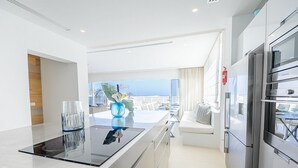 A modern kitchen with a large island, stainless steel appliances, and a view of the ocean. - Protaras holiday villa - rentprivatevillas 100 (Protaras)