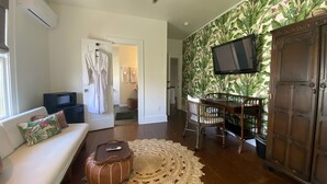 Een woonkamer met een bank, een salontafel, een televisie en een kast.