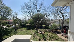 A residential backyard with a lawn, patio furniture, and a small shed.
