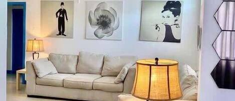 Ein Wohnzimmer mit einer Couch, einem Couchtisch und Wandbildern.