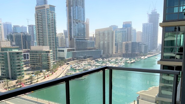 A high-rise building with a view of a marina and cityscape. - 2-BR Marina View Retreat at Marina Quays - DSY (Dubai)