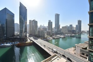 A cityscape with modern high-rise buildings, a bridge, and a marina. - 2-BR Marina View Retreat at Marina Quays - DSY (Dubai)