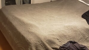 Une chambre à coucher avec un lit, une table de chevet et un miroir.