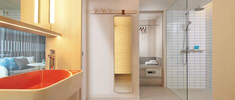 Un baño moderno con una bañera grande, cabina de ducha de vidrio y un toallero a la vista.