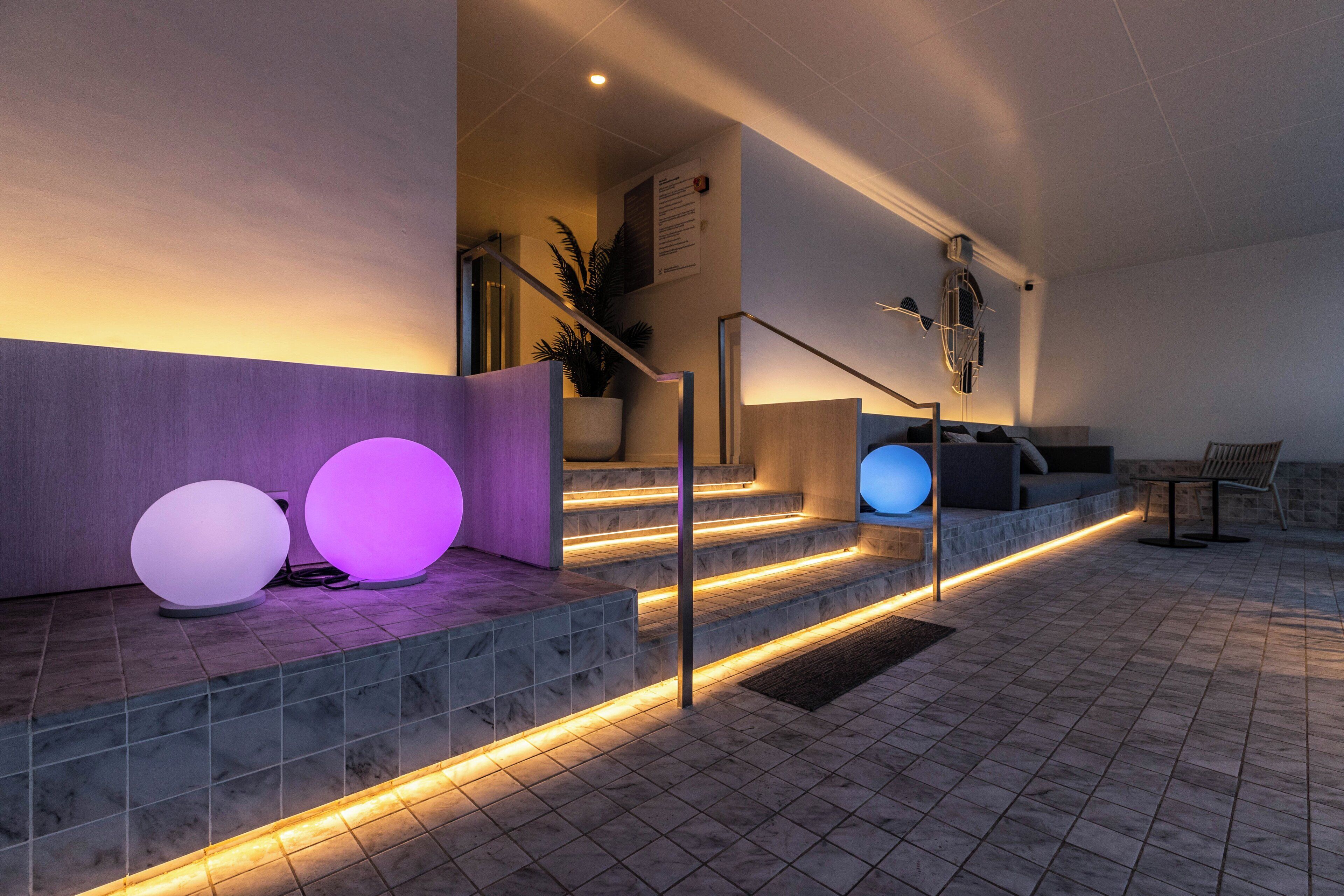 A modern staircase with illuminated steps and decorative spherical lights.