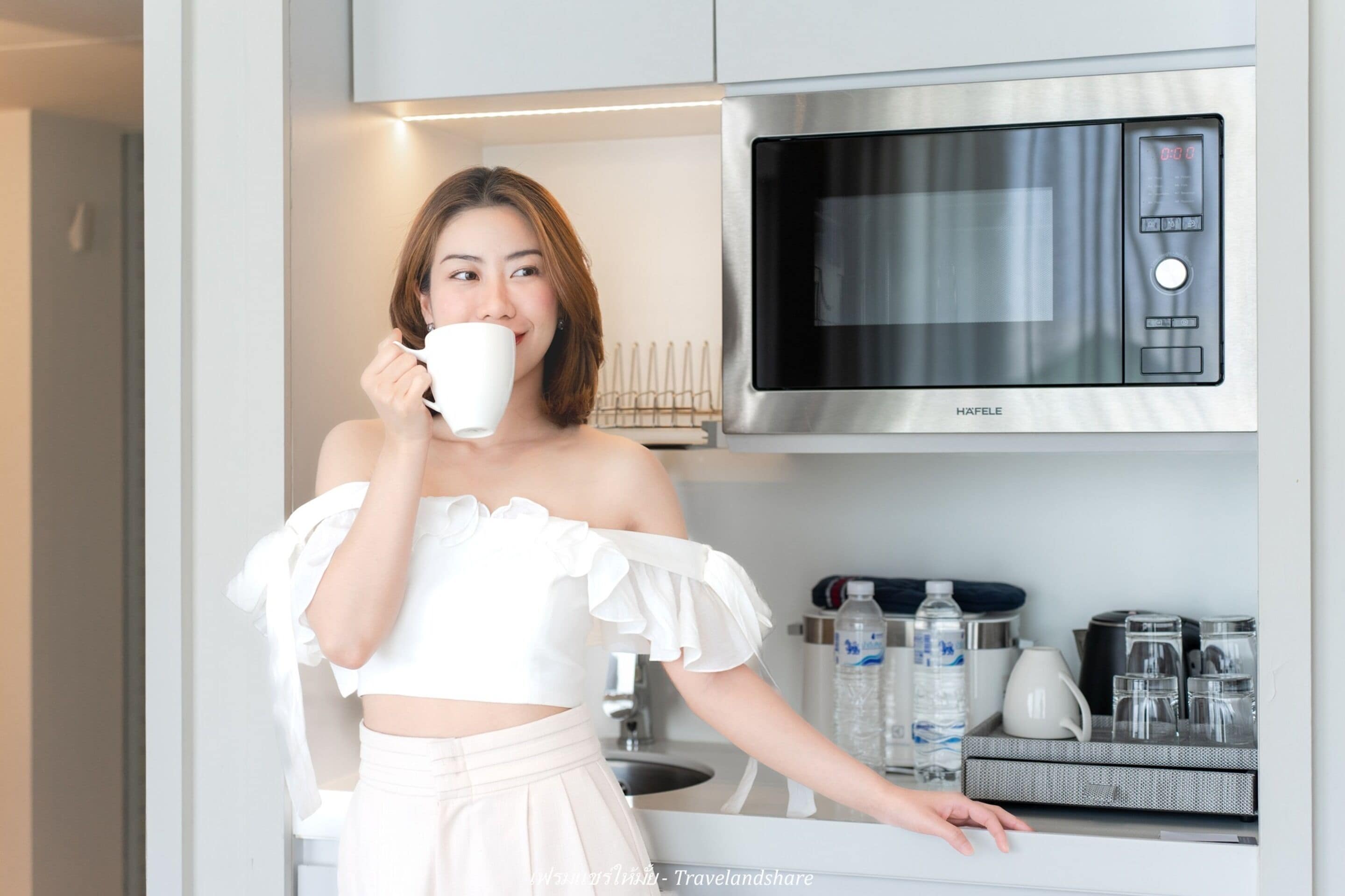 A modern kitchen with a stainless steel microwave, a water dispenser, and a coffee maker.