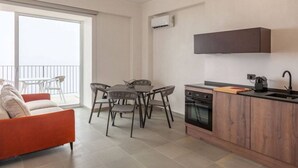 Een modern appartement met een eethoek, keuken en balkon met uitzicht.