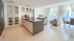 Une cuisine moderne dotée d’un îlot central, de meubles de rangement intégrés et d’un coin repas avec un canapé et des chaises.